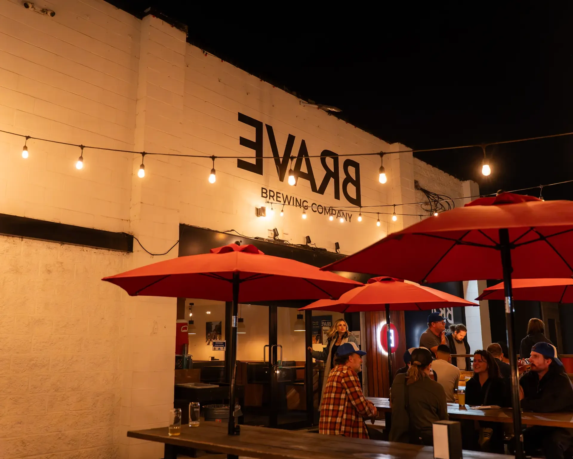 Brave Brewing patio at night under red umbrellas