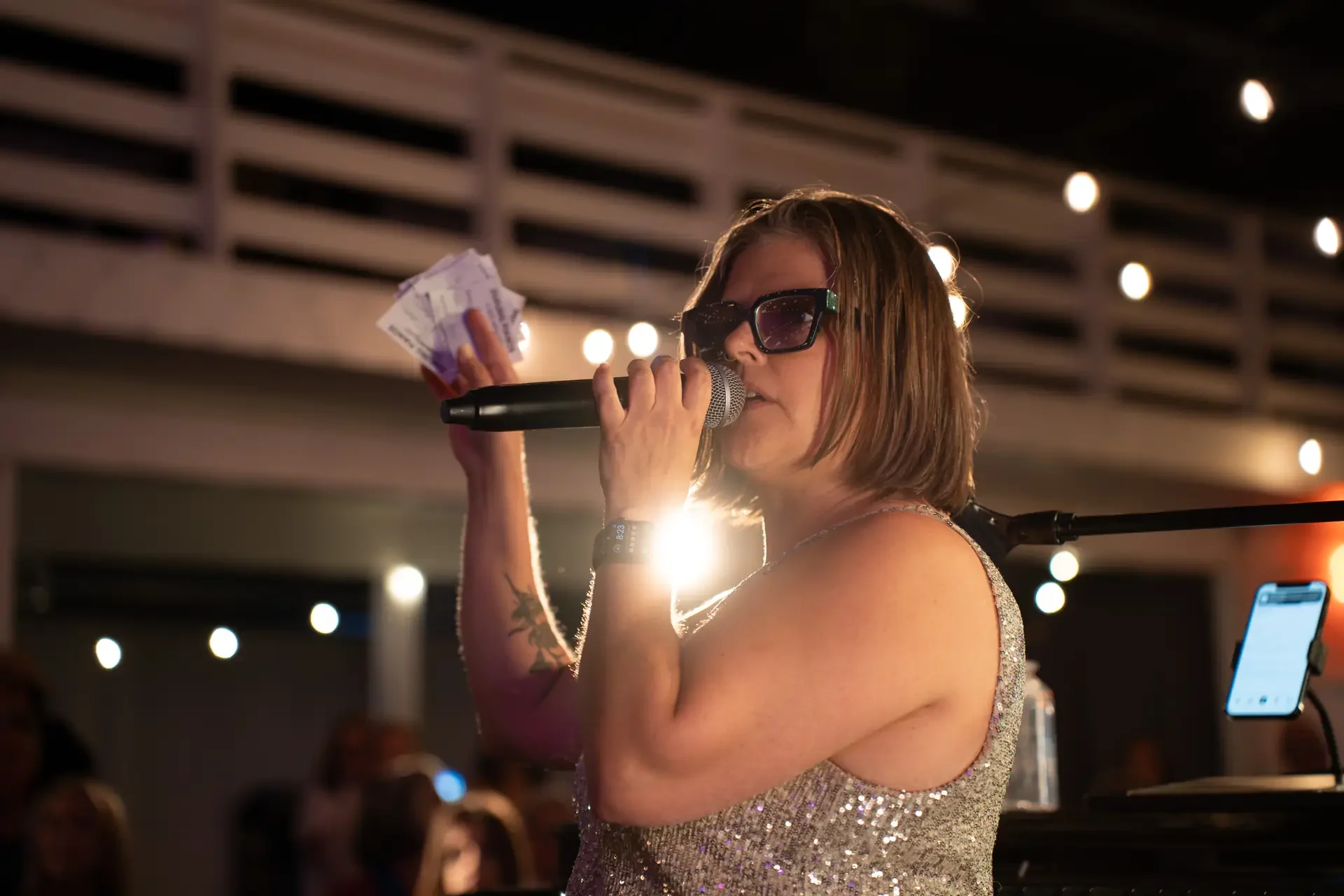 A singer performing under string lights